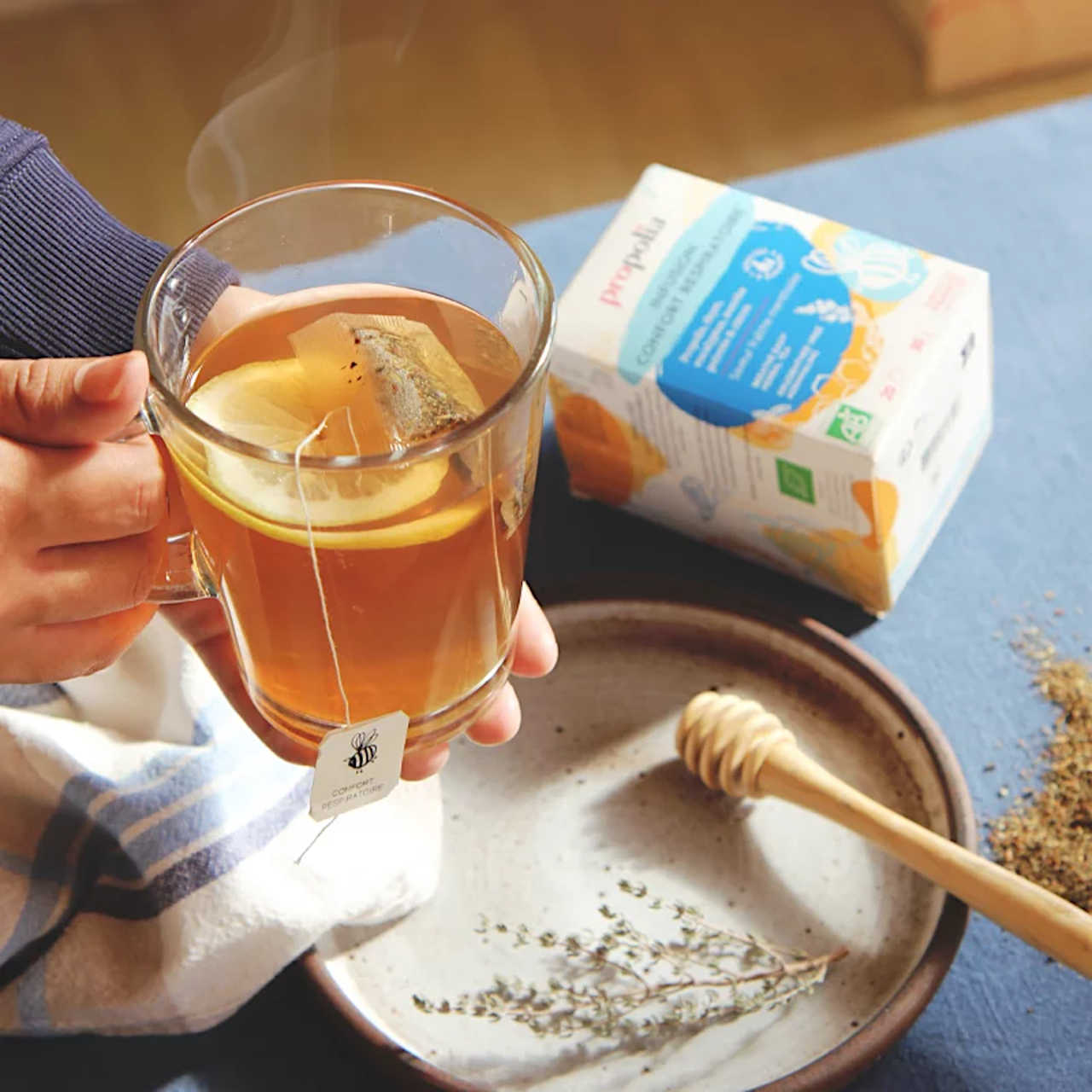 Heißer Kräutertee zur Linderung von Atemwegsbeschwerden Stilleben: Glas mit aufgegossenem Tee und Teebeutel